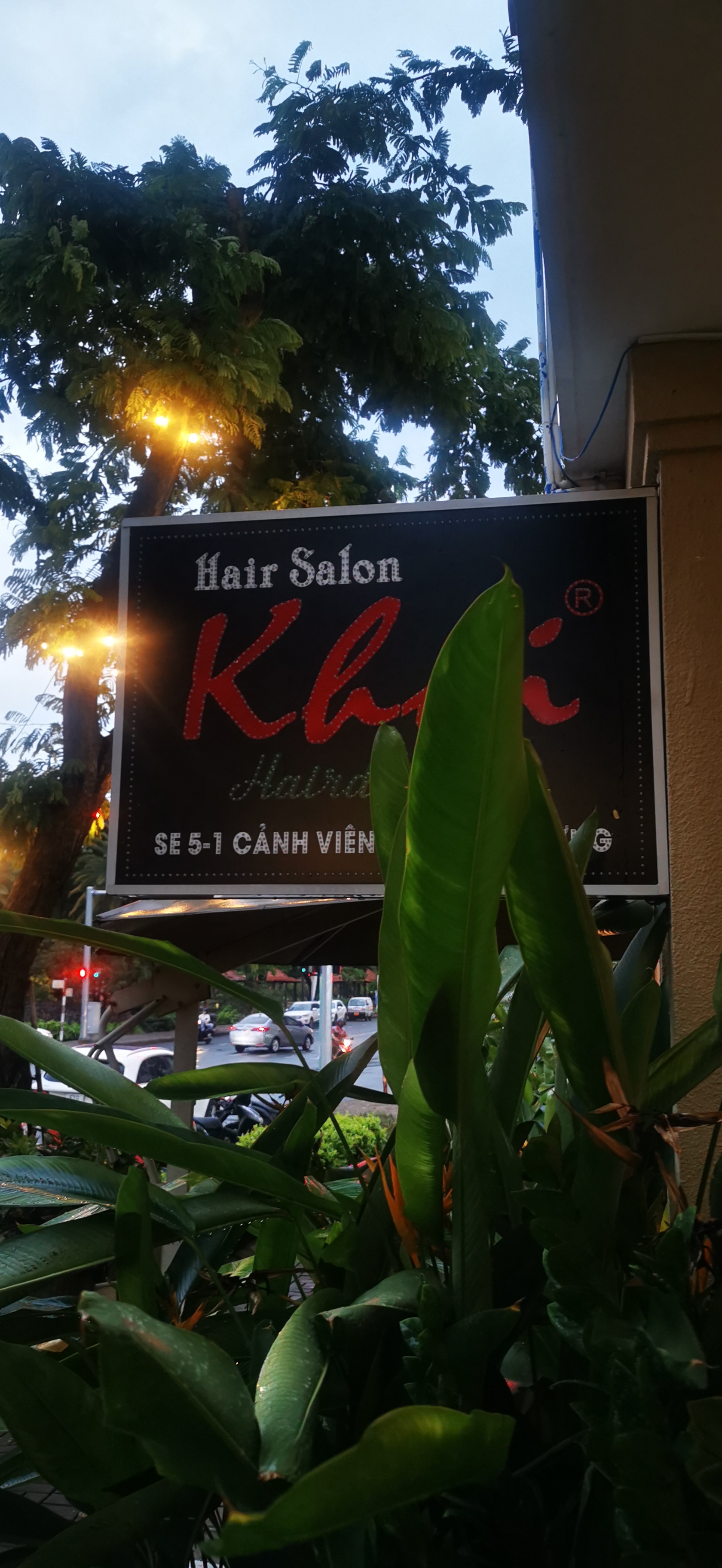 Mặt tiền salon Khôi hair PMH với biển hiệu chữ trắng nhìn từ vỉa hè